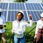 African american technician checks the maintenance of the solar panels. Group of three black engineers meeting at solar station.